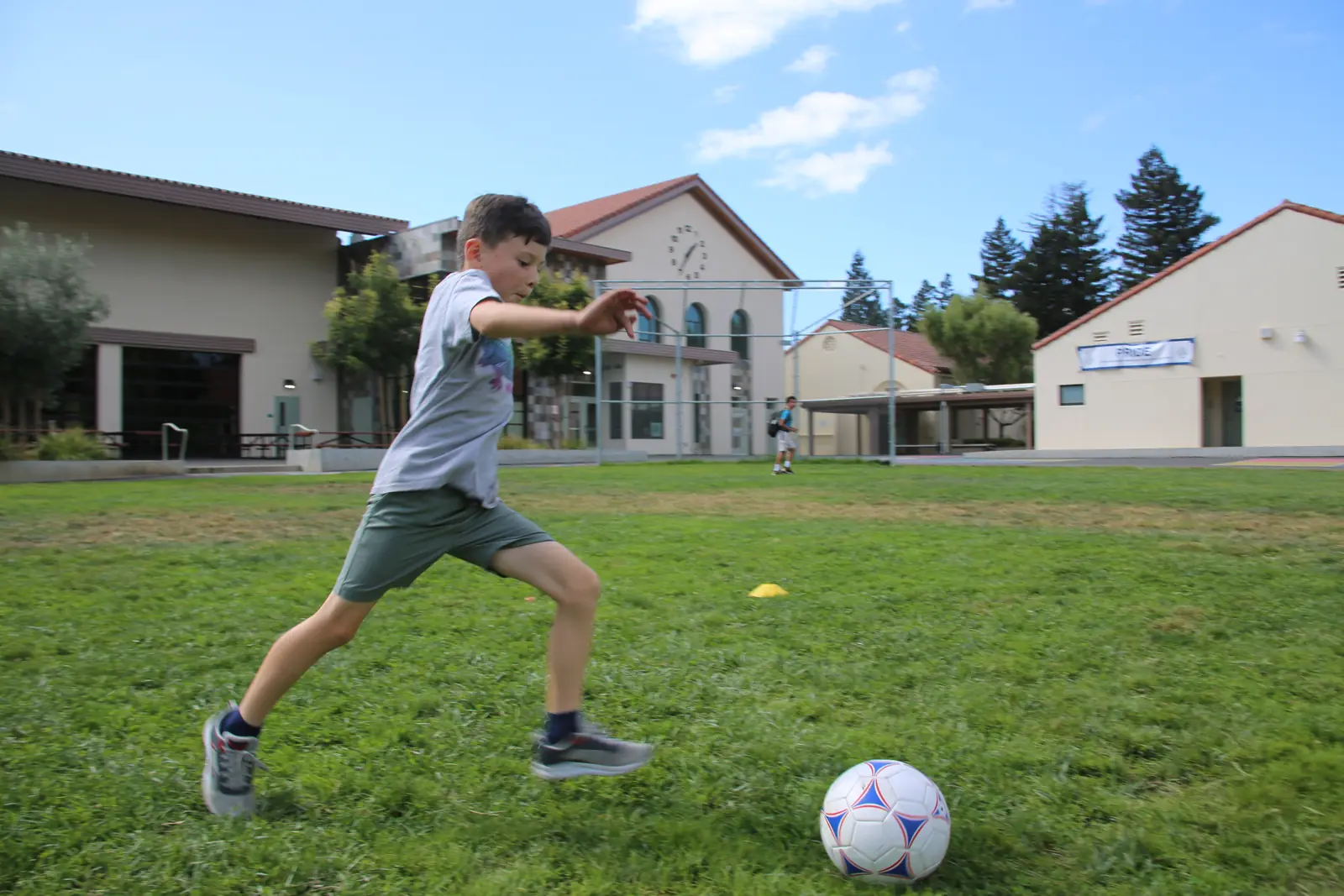 Young player sprinting toward a soccer ball on the school field