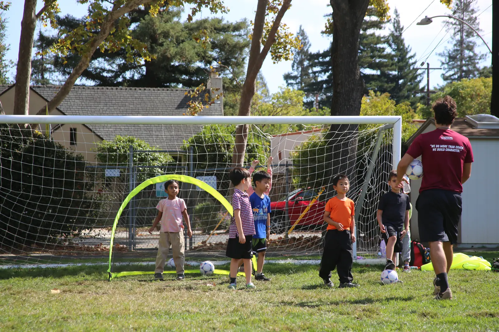 Group of young players at the goal with their coach