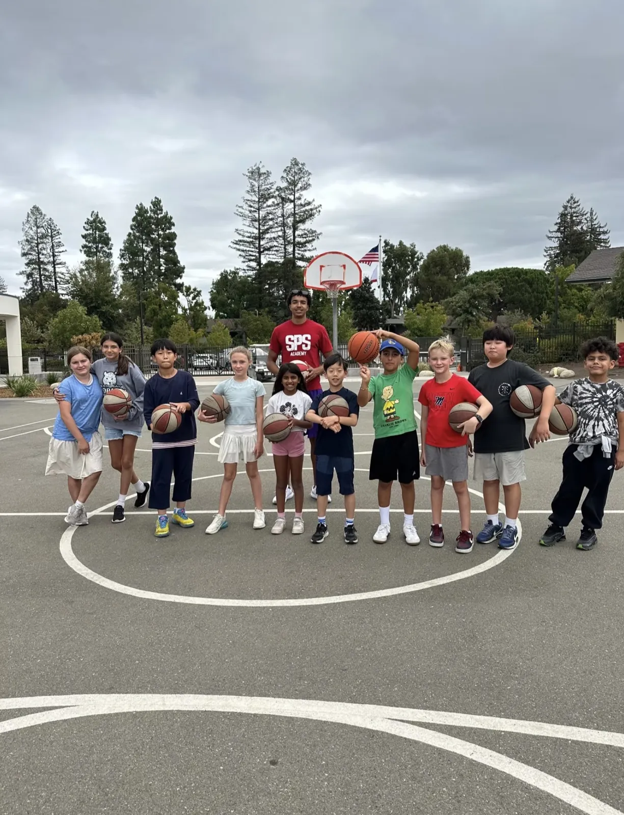 Group of students with basketballs on an outdoor school court