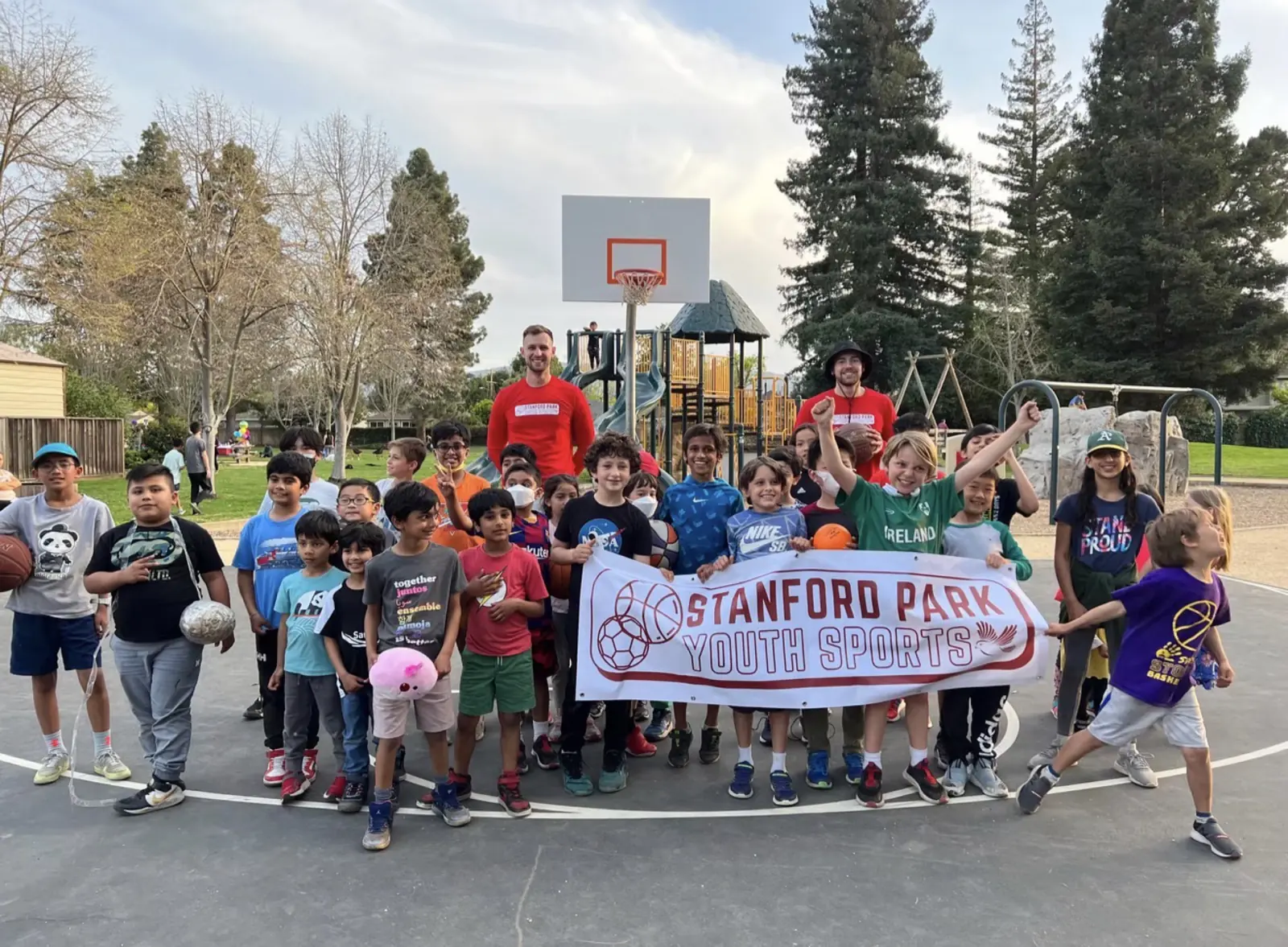 Big group of students holding a Stanford Park Youth Sports banner